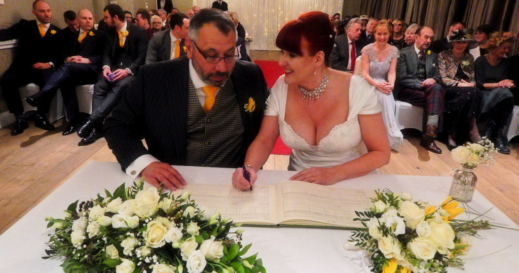 David and Debbie at their own Wedding signing the registry book.